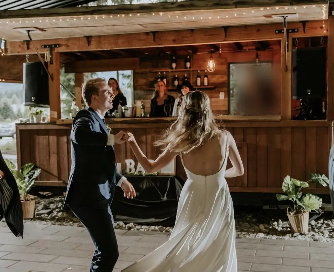Newlyweds dancing in front of the Boombox bar at an Audain Art Museum wedding in Whistler