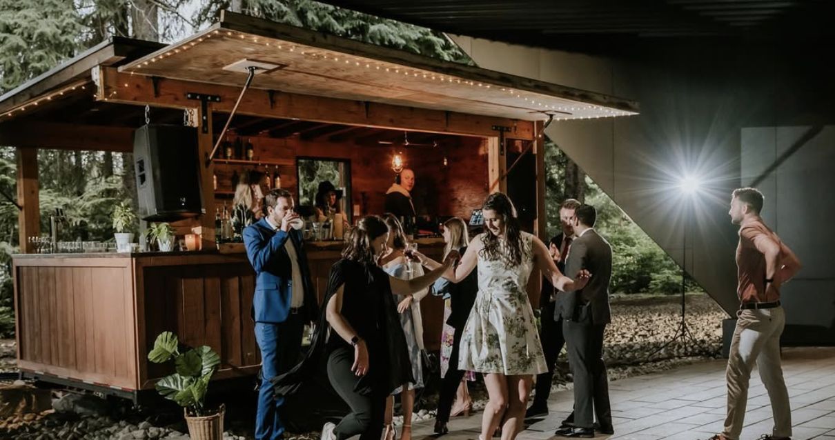 Guests dancing in front of the lit-up Boombox bar