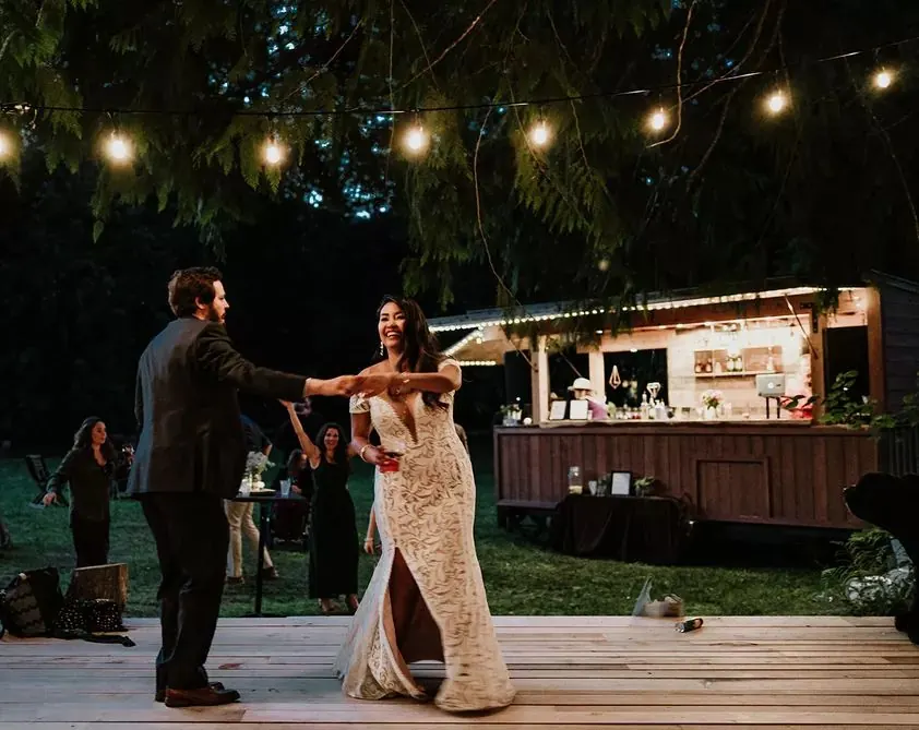 Wedding couple dancing under string lights in front of the Whistler Boombox bar